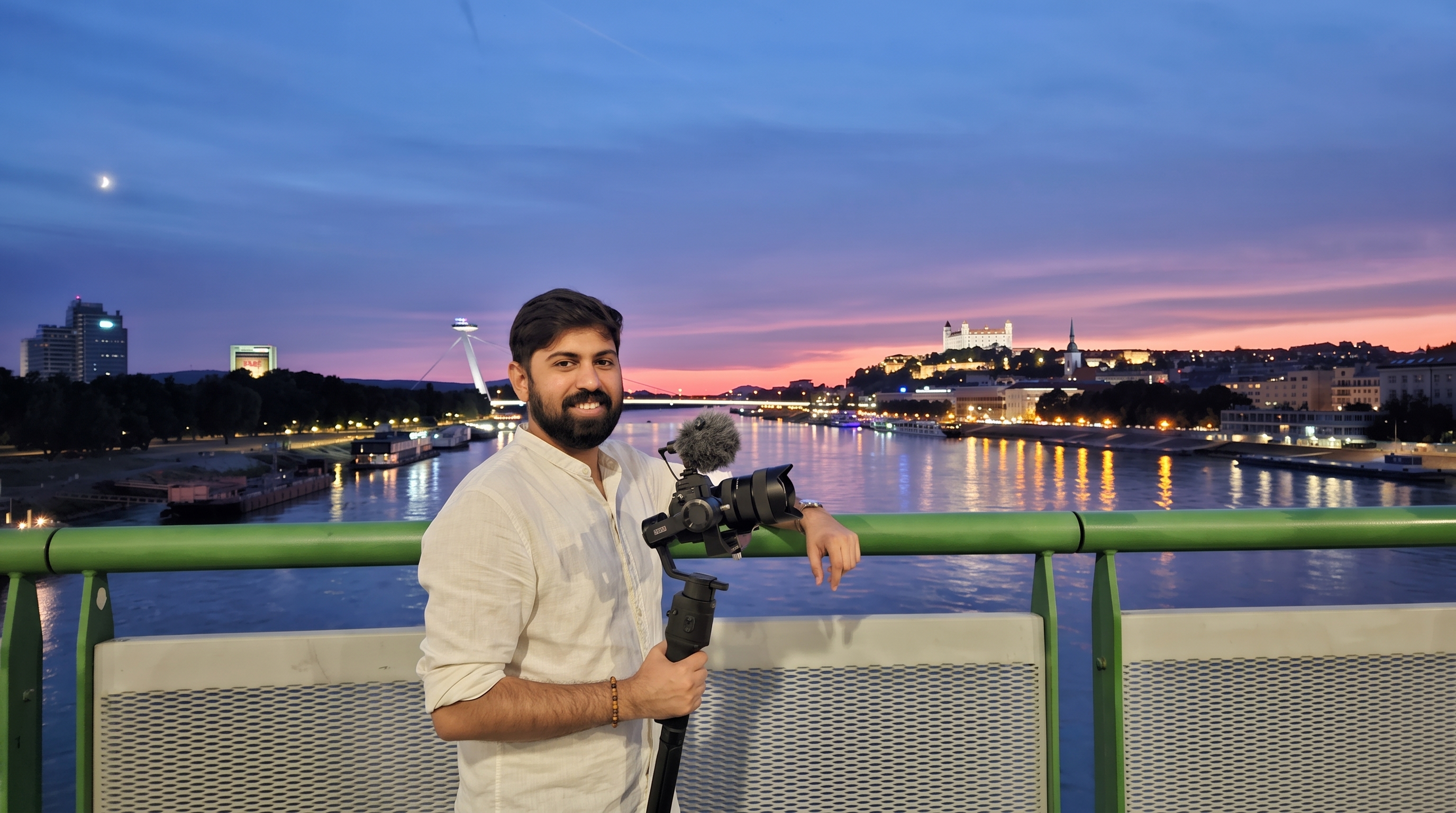Parantap Bharad on a bridge over the Danube at dusk, holding a camera on a gimbal